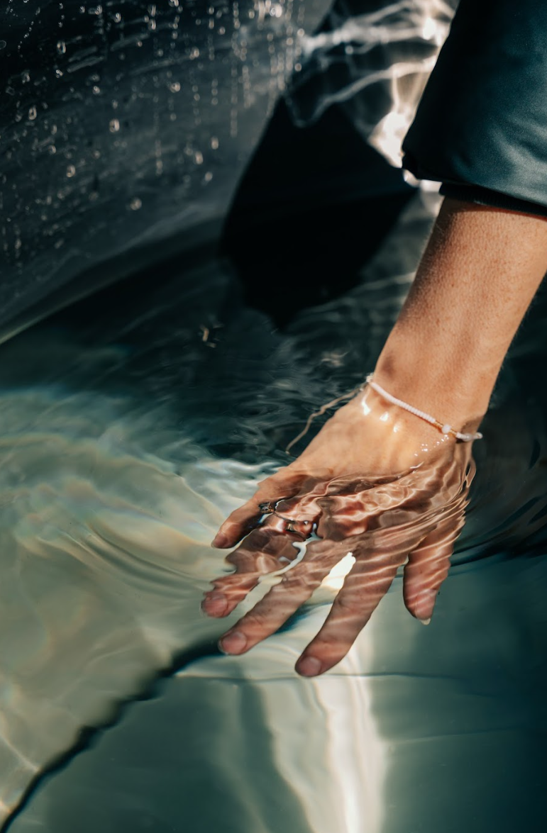 Personhånd i isbad med rent, krystalklart vand og ring