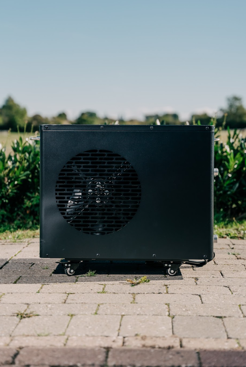 Icekore køleenhed udenfor på fliser blandt grønne buske